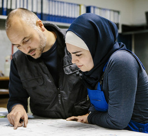 Zwei Techniker besprechen einen Plan Zwei Techniker besprechen den Plan für eine Maschine