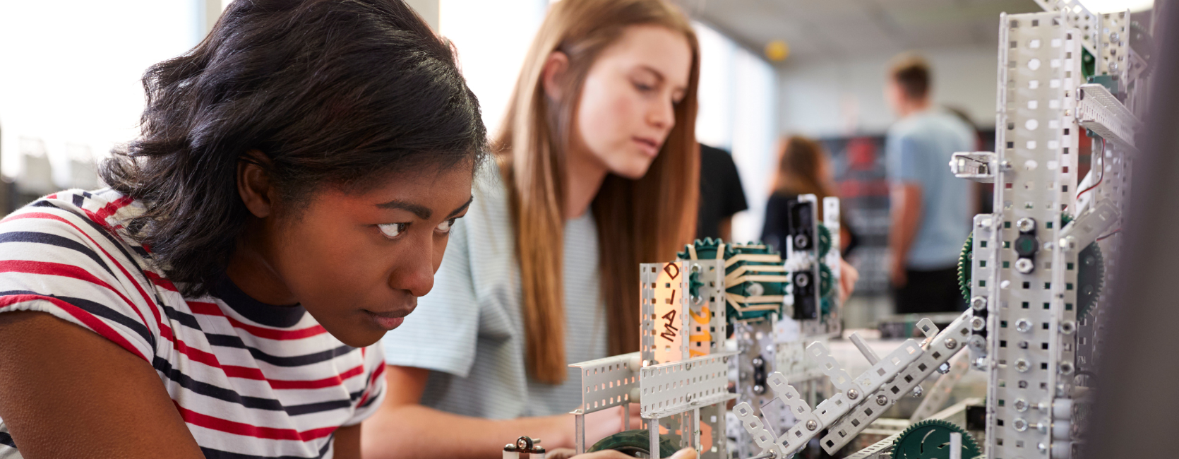 Zwei Studentinnen bauen eine Maschine in der Robotik- oder Ingenieursklasse